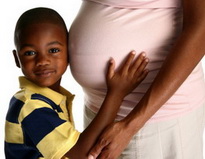 Boy holding pregnant mother's stomach - Pediatric Dentist in Keller, Fort Worth and Southlake, TX - Bridget McAnthony, DDS